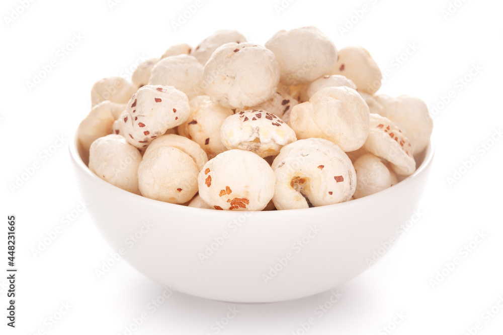 Close-up of organic makhane (puffed lotus seed or Fox nuts) in a white ceramic bowl over white background. Close-up of organic makhane (puffed lotus seed or Fox nuts) in a white ceramic bowl over white background.