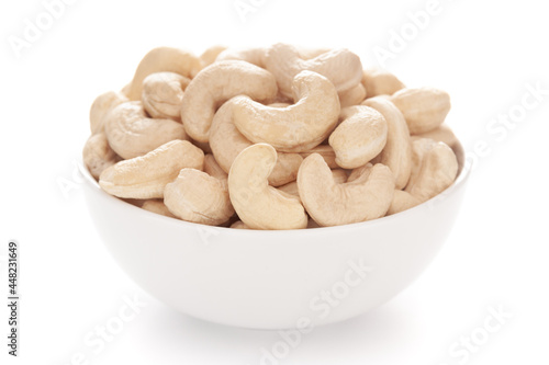 Close-up Organic dry fruit cashew nut (Anacardium occidentale)  in white ceramic  bowl on white background photo