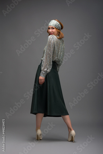full length portrait of a fashionable aged woman isolated on grey