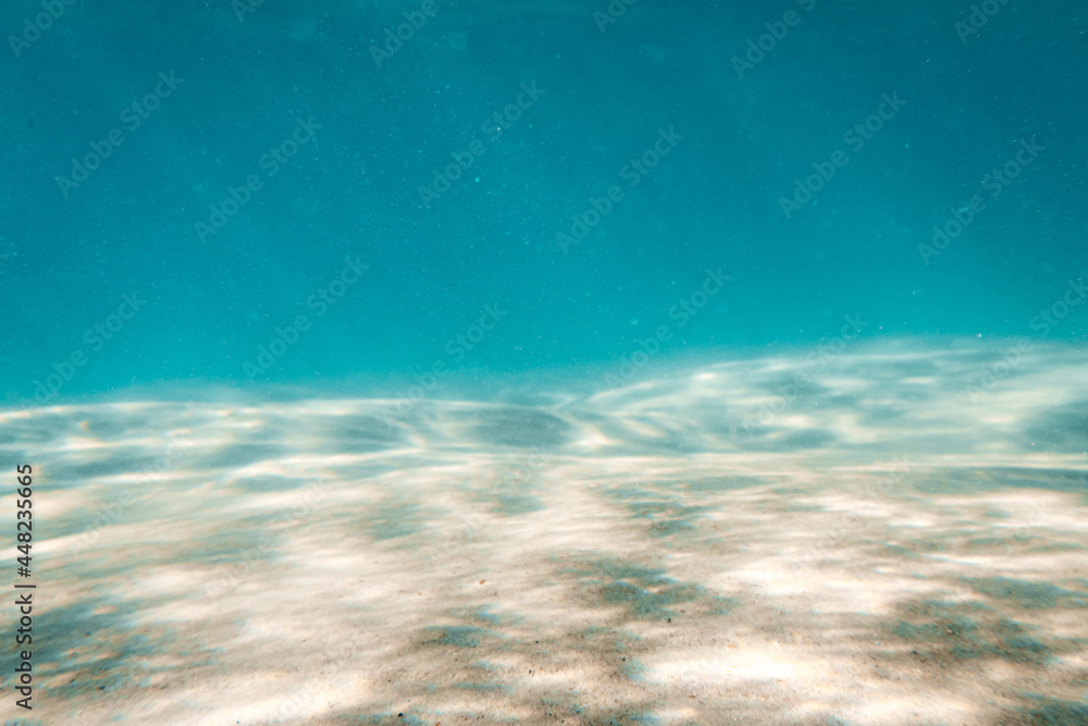 Underwater Scene whit Sunbeams Coming Through the Water and Reflected on Sand Floor. Background