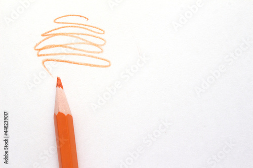 orange pencil with scroll on white background. High quality photo