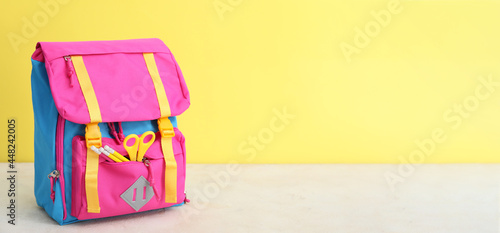 School backpack on table against color background with space for text