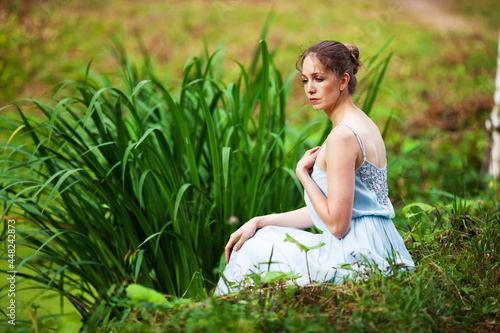 Wallpaper Mural Beautiful woman in a blue dress sits on the shore of the lake Torontodigital.ca