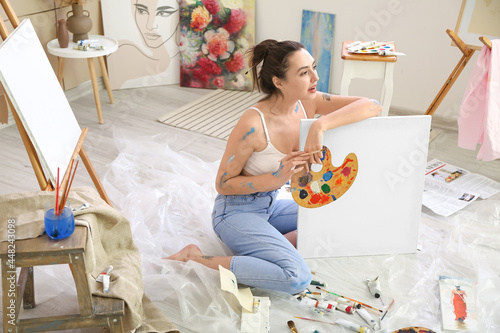 Young female artist paintin...
