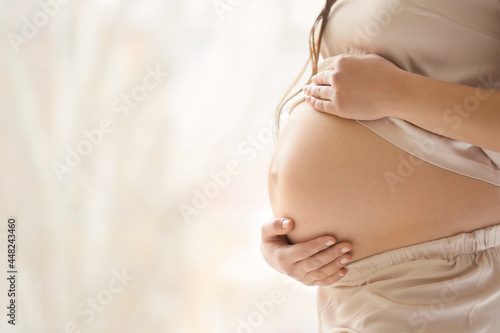 Young pregnant woman near w...