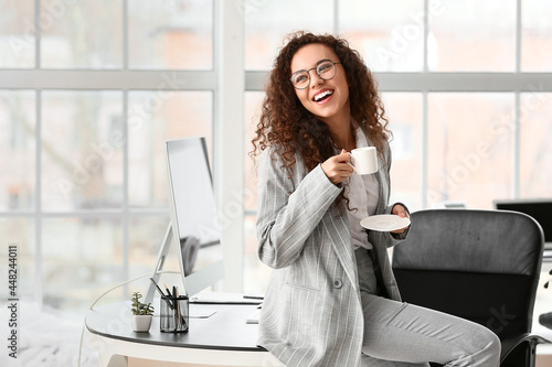 Happy young woman with cup ...
