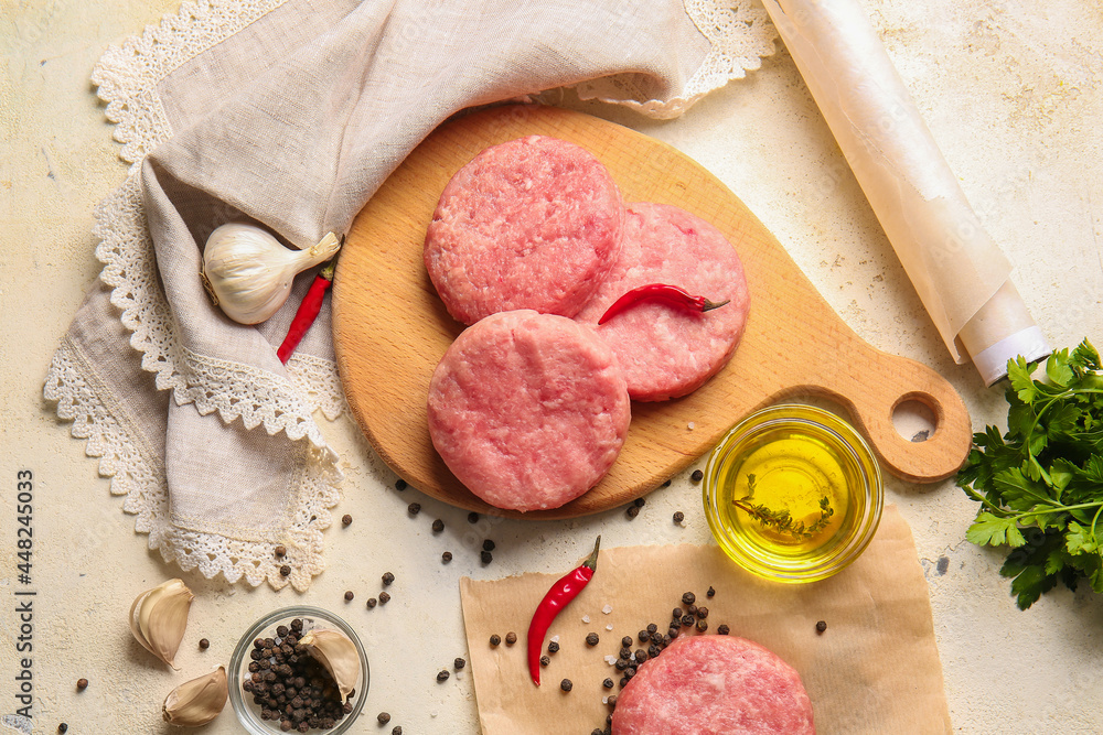 Composition with raw cutlets made of fresh forcemeat on light background