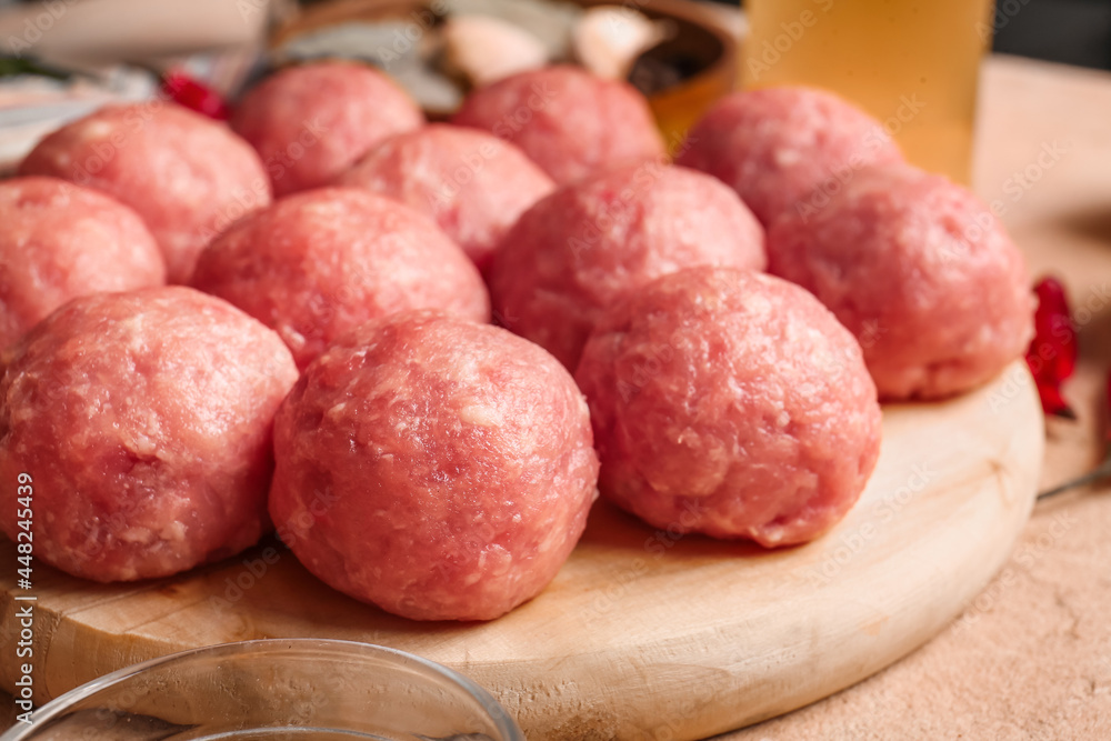 Wooden board with raw cutlets made of fresh forcemeat on table, closeup Wooden board with raw cutlets made of fresh forcemeat on table, closeup