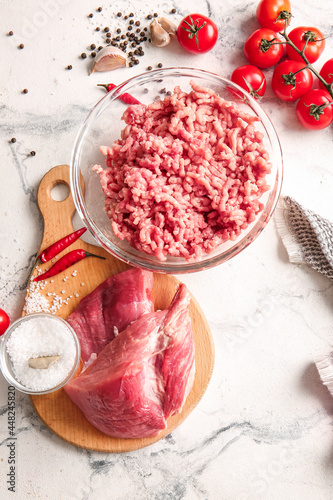 Bowl with fresh forcemeat and ingredients on light background photo