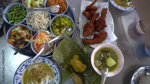 Family eating Kanom jeen, rice vermicelli noodle with curry and vegetables and fried chicken local traditional meal of Phuket Thailand photo