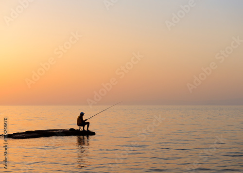 Fisherman silhouetted against a dusk sky © PhotoEdit