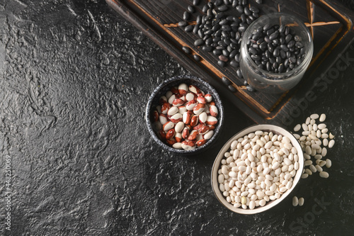 Different types of beans on dark background