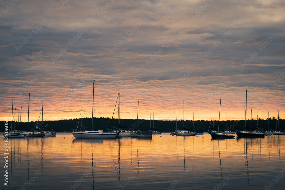 sunrise over lake with sailboats