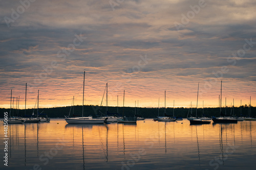sunrise over lake with sailboats