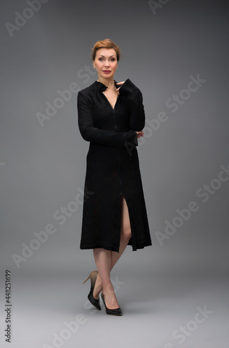 full length portrait of a fashionable aged woman isolated on grey