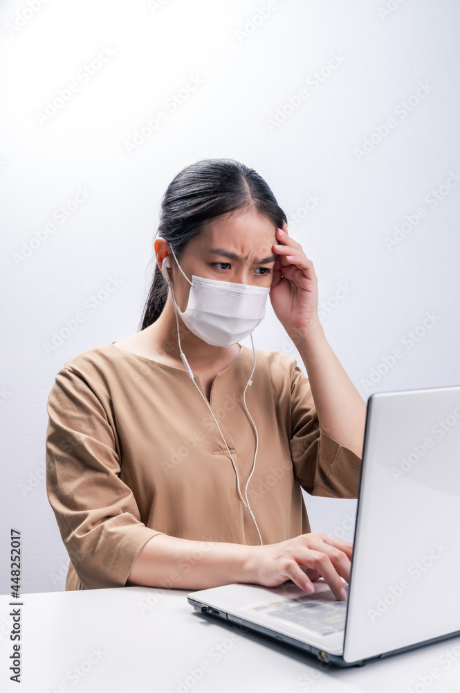 Asian woman wears protective mask and worry about Coronavirus on her working day on white background Asian woman wears protective mask and worry about Coronavirus on her working day on white background
