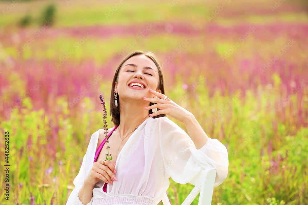 Beautiful young woman relaxing in blooming field Beautiful young woman relaxing in blooming field