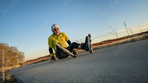 Inline skating accident - confused male skater sitting on concrete bike trail,  late fall scenery in Colorado