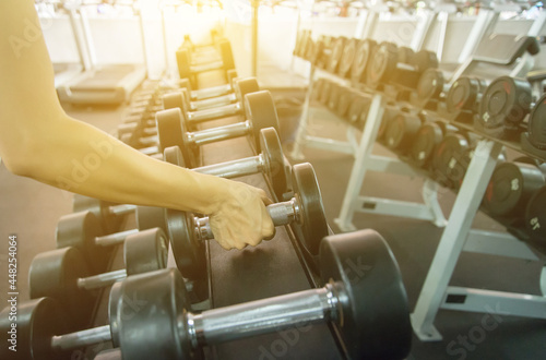 woman in fitness using hands to lift dumbbells to exercise the arms health care concept