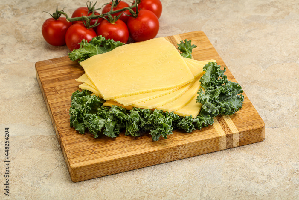 Sliced Gauda cheese over board Sliced Gauda cheese over board