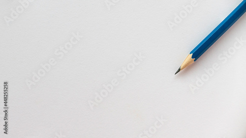 Blue pencil isolated on a blank white paper with copy space.