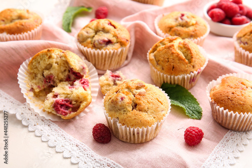 Tasty raspberry muffins on light background, closeup