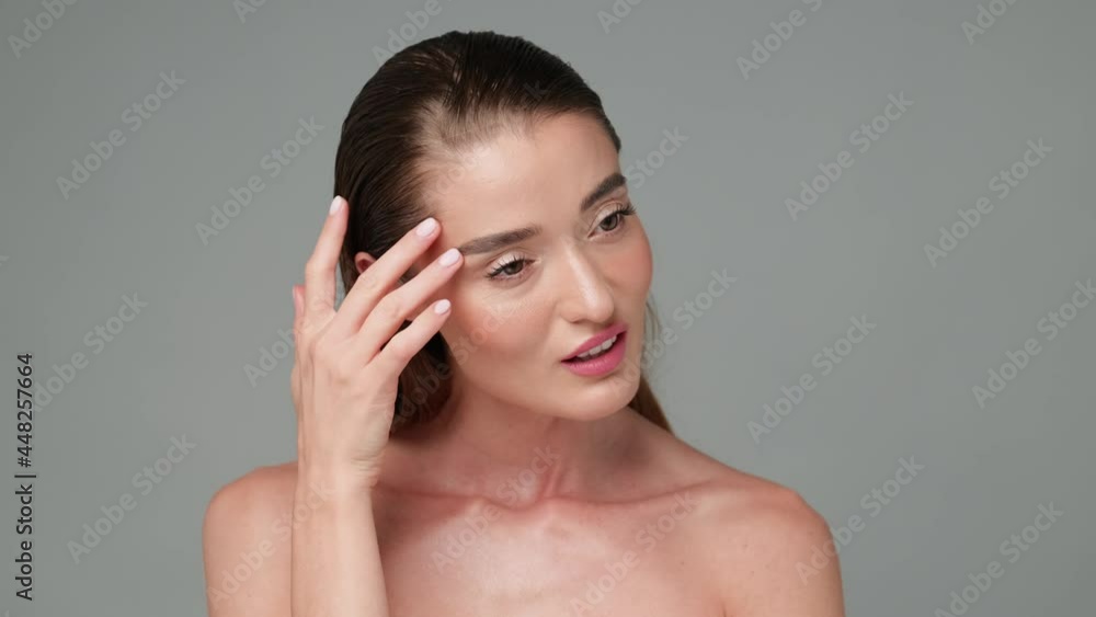 Beautiful Young Woman with Clean Fresh Skin standing over light grey background Beautiful Young Woman with Clean Fresh Skin standing over light grey background