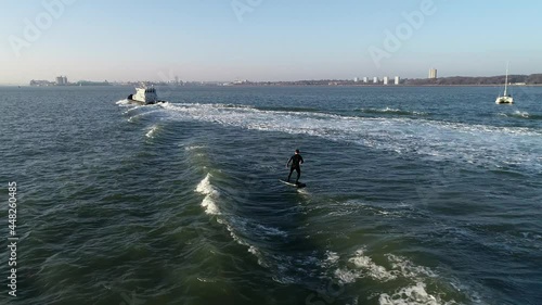 E Foil Sunset boating on the water. Paddleboard, stand-up surfing on electric foil. Aerial drone shot at sunrise. Luxury lifestyle, superyacht water toys. photo