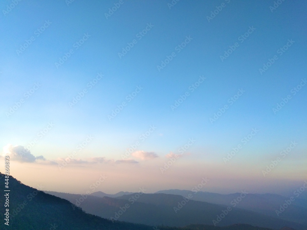High altitude view with intricate green mountains and orange blue sky on vacation.