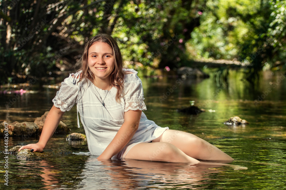 Fototapeta premium woman with white dress near stream of water