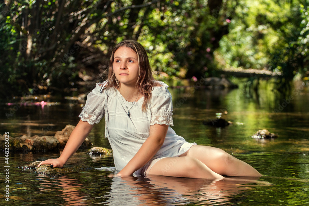 Fototapeta premium woman with white dress near stream of water