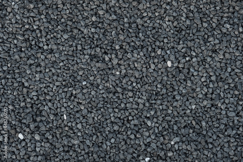 Close-up of crushed stone, granite gravel. Rough geometric seamless pattern and background of building material.