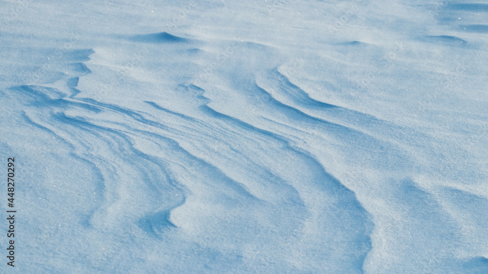 Snowy background, snow-covered surface of the earth after a blizzard in the morning in the sunlight with distinct layers of snow Snowy background, snow-covered surface of the earth after a blizzard in the morning in the sunlight with distinct layers of snow