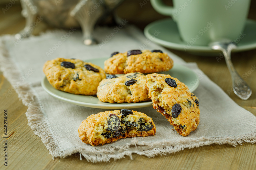 Fresh baked homemade oatmeal cookies with raisins and sunflower seeds on wooden background