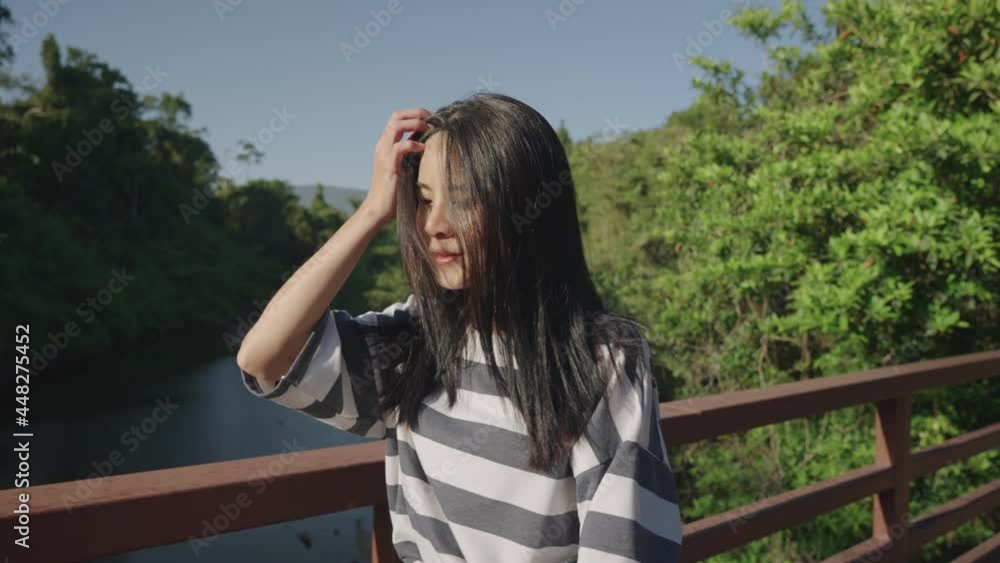 beautiful Asian female walking on the wooden bridge inside creek park, exploring nature, enjoying surrounding environment, woman empower exploring outdoor activity, vitality wellness healthy girl beautiful Asian female walking on the wooden bridge inside creek park, exploring nature, enjoying surrounding environment, woman empower exploring outdoor activity, vitality wellness healthy girl