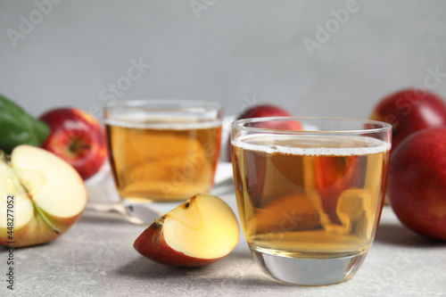 Delicious cider and ripe apples on grey table. Space for text