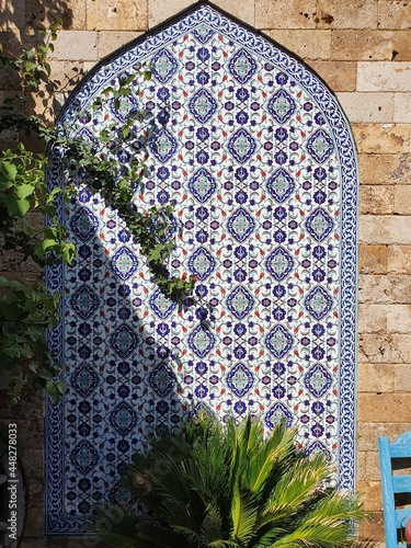 Wall decoration with painted tiles. Painted in an Asian style in a blue shade.