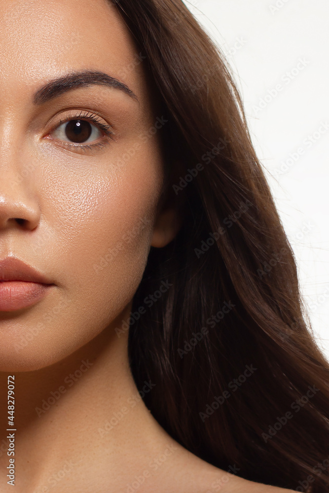 Fototapeta premium Half beauty portriet woman smiling at the camera with a snow-white smooth. Beautiful natural makeup, puffy lips, smooth and thick eyebrows, extremely long eyelashes. Clean fresh skin