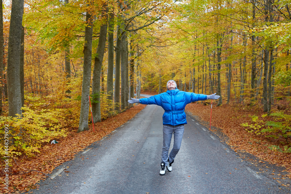 Young woman posing in the autumn forest on the road.