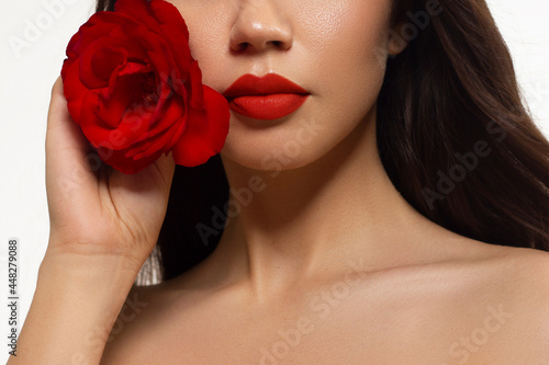 Half a beauty portrait with beautiful fashionable evening make-up with flowers  black jiggles on eyes and extremely long eyelashes. Red lipstick on the lips. Cosmetology and spa facial skin care