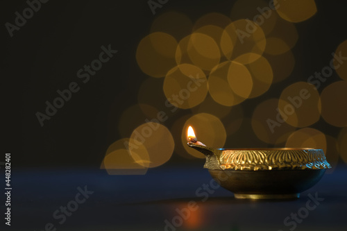 Lit diya lamp on dark table  space for text. Diwali celebration