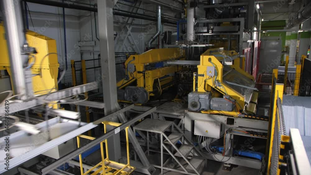 Automated equipment with vacuum cups transports domestic refrigerator detail along modern production plant workshop Automated equipment with vacuum cups transports domestic refrigerator detail along modern production plant workshop