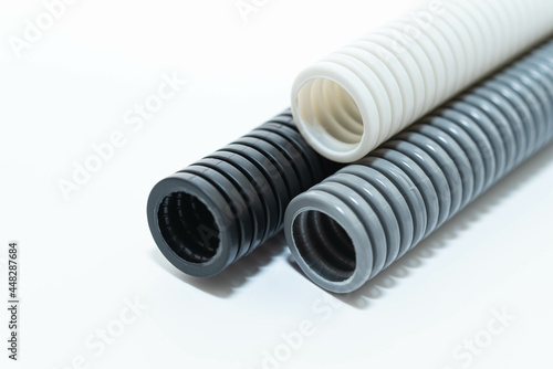 PVC flexible electrical conduit isolated on white background. Plastic curvilinear hoses. Colored corrugated pipe for installation of electrical cable 