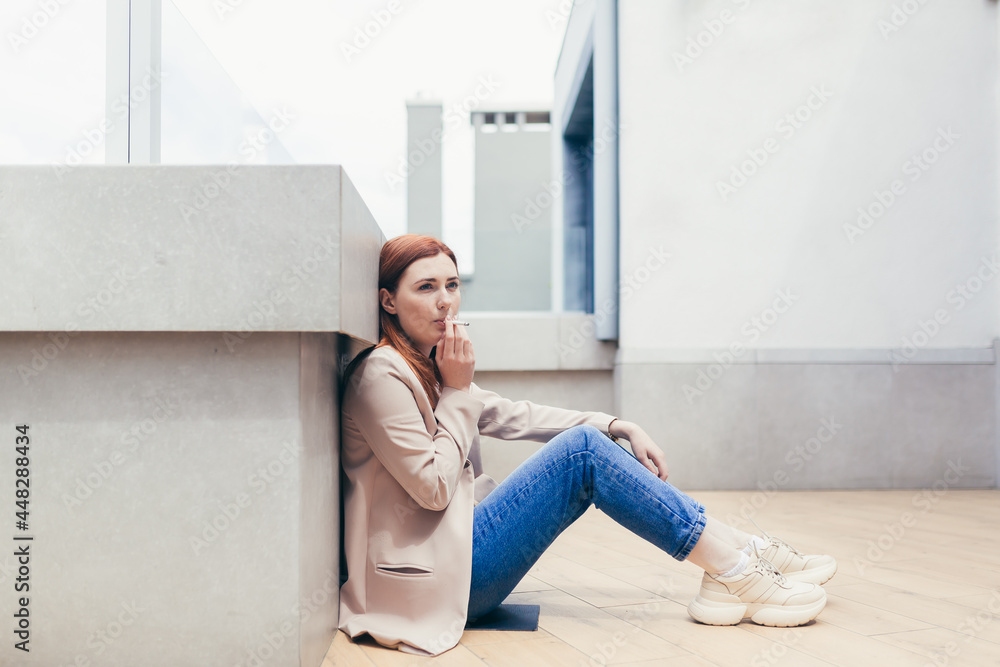young frustrated depressed woman sitting on the street lost her job or has financial problems smoking a cigarette. lonely female student girl has stress at work. unemployed Lady with grief outdoors young frustrated depressed woman sitting on the street lost her job or has financial problems smoking a cigarette. lonely female student girl has stress at work. unemployed Lady with grief outdoors