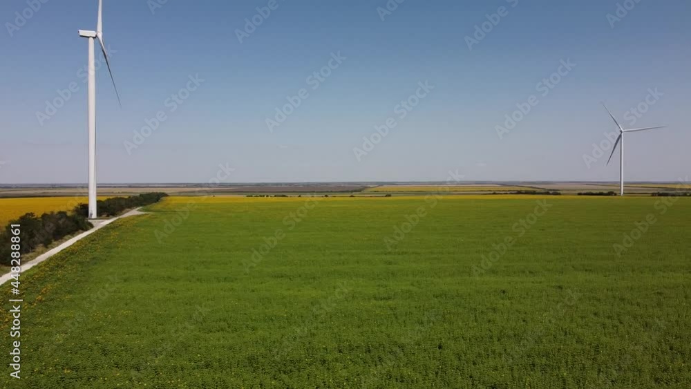 Aerial drone view of a flying over the wind turbine and agricultural fields. Sunflower field. Windmill. Wind farm. Aerial drone view of a flying over the wind turbine and agricultural fields. Sunflower field. Windmill. Wind farm.