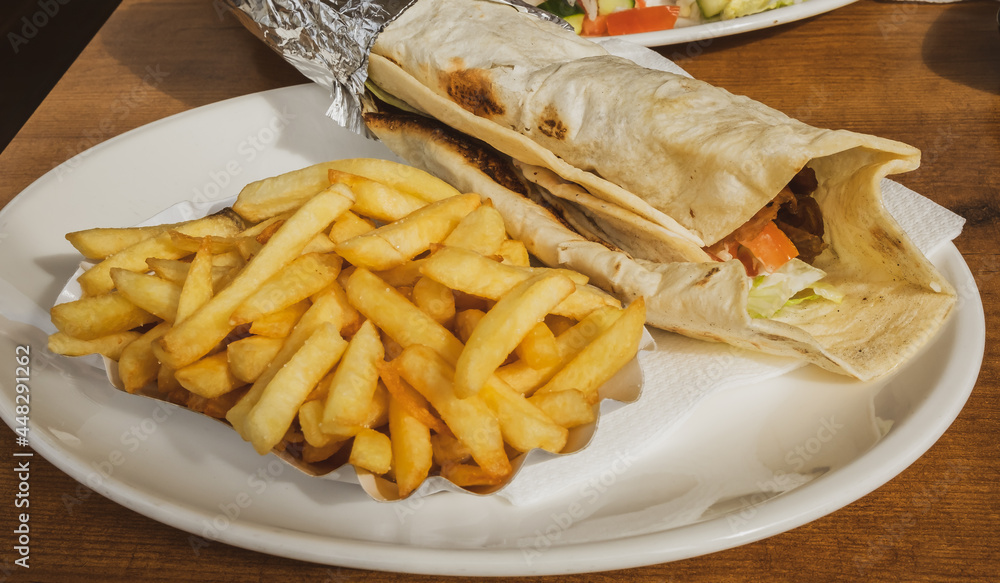 Kebab and French fries recipe on a white dish table in an European country. Kebab and French fries recipe on a white dish table in an European country.