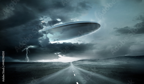 Fototapeta Naklejka Na Ścianę i Meble -  A large alien spaceship emerging from storm clouds on earth. 3D illustration.
