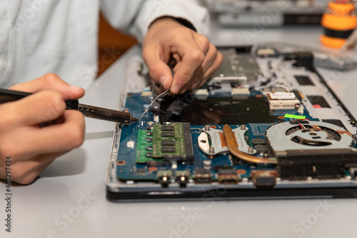 technician soldering a broken computer board