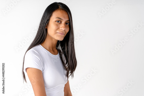 Medium short portrait of a beautiful smiling latin woman in white shirt on white background.
