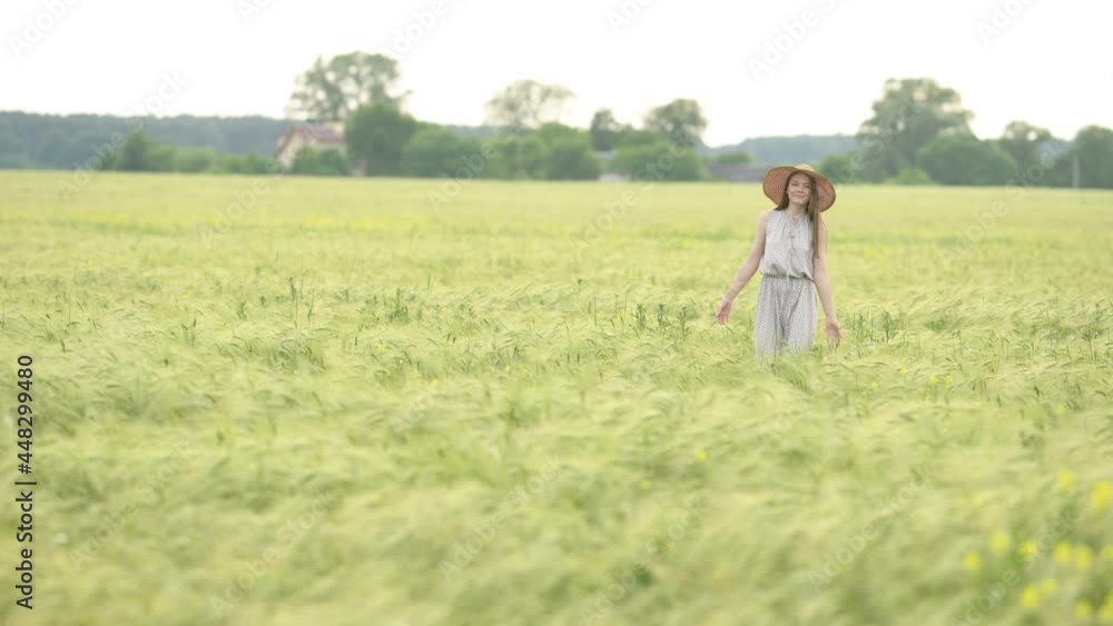 Portrait of a young beautiful woman in dress walks through a wheat field at a sunny day. Happy free girl run in park agricultural land. Freedom concept. Portrait of a young beautiful woman in dress walks through a wheat field at a sunny day. Happy free girl run in park agricultural land. Freedom concept.